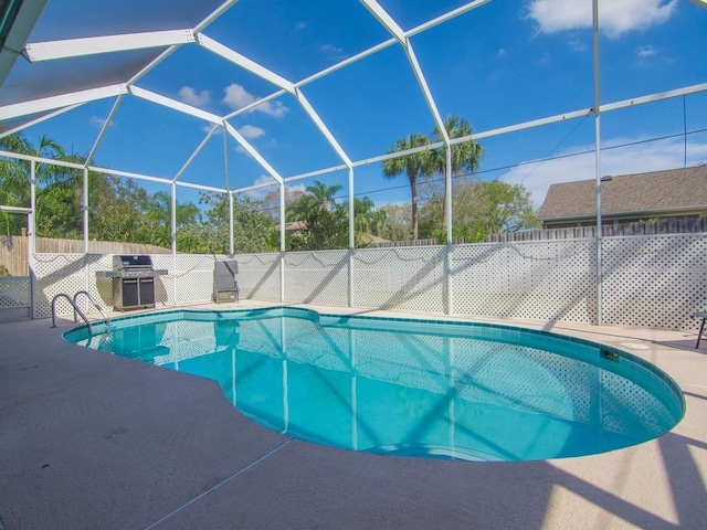 view of swimming pool featuring area for grilling, a lanai, and a patio