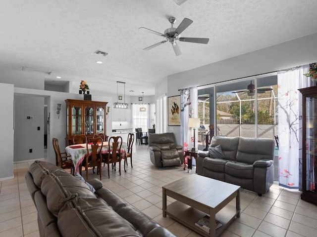 tiled living room with ceiling fan and a textured ceiling