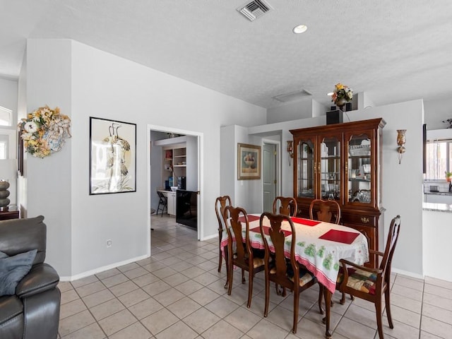 dining space featuring light tile patterned floors and a textured ceiling