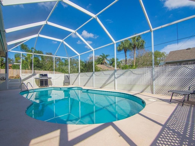 view of swimming pool with a patio area, grilling area, and glass enclosure