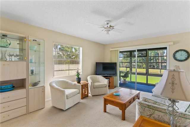 living area featuring a textured ceiling, ceiling fan, and carpet flooring