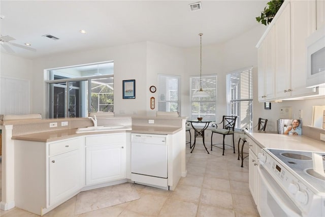 kitchen featuring white cabinetry, a wealth of natural light, white appliances, and decorative light fixtures