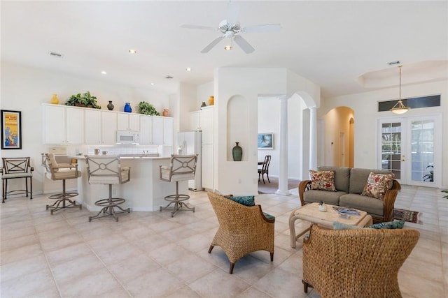 living room featuring ornate columns and ceiling fan