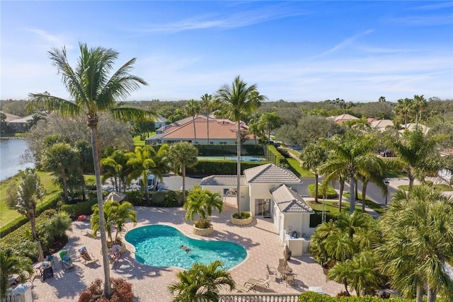 view of swimming pool featuring a patio and a water view