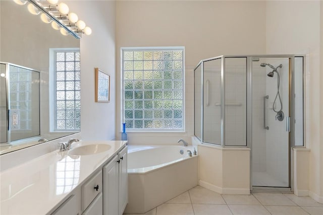 bathroom with tile patterned flooring, shower with separate bathtub, and vanity