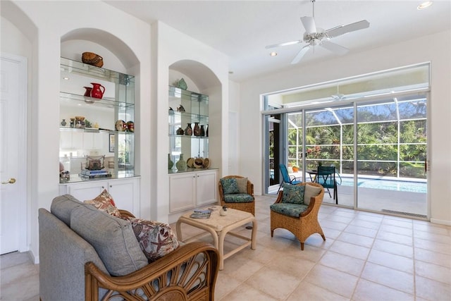 living area featuring light tile patterned flooring, built in features, and ceiling fan