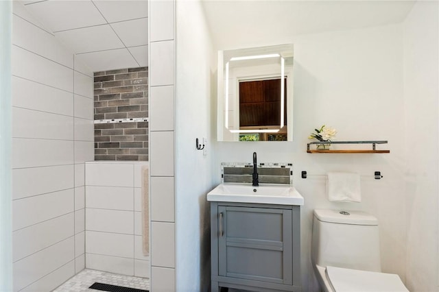 bathroom with vanity, toilet, and a tile shower