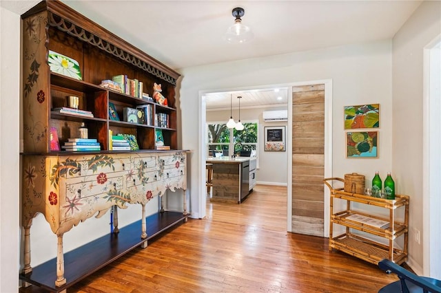 hallway featuring hardwood / wood-style flooring and a wall mounted AC