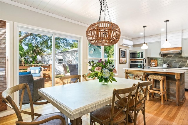 dining room with sink, crown molding, wooden ceiling, light wood-type flooring, and an AC wall unit