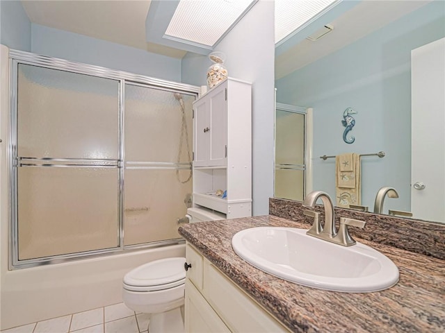 full bathroom featuring tile patterned floors, toilet, combined bath / shower with glass door, and vanity