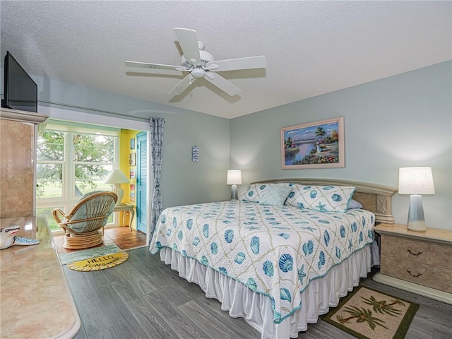 bedroom featuring dark wood-type flooring, ceiling fan, and a textured ceiling