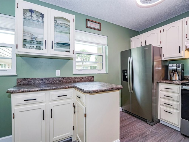 kitchen with white cabinetry, stainless steel fridge, a textured ceiling, and light wood-type flooring