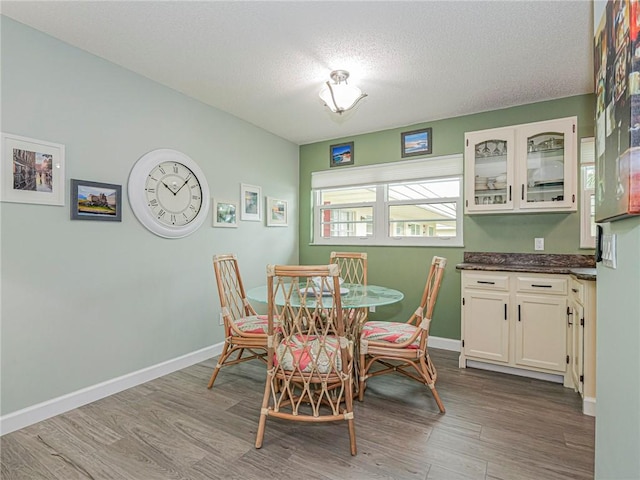 dining space featuring hardwood / wood-style flooring and a textured ceiling