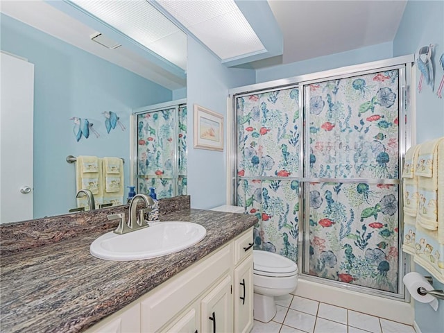 bathroom with tile patterned floors, toilet, vanity, and a shower