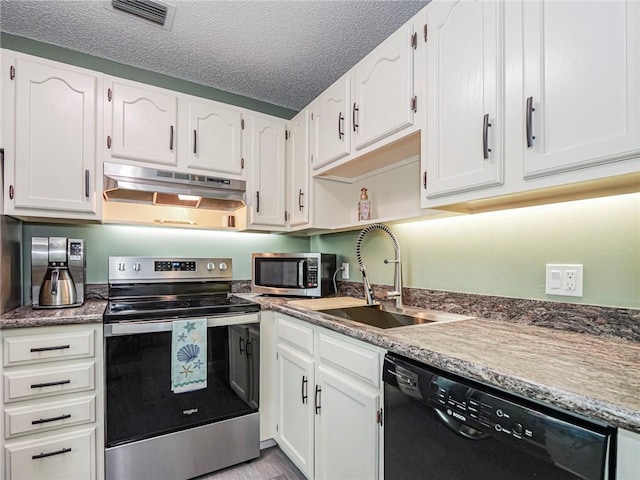 kitchen featuring stainless steel appliances, white cabinetry, sink, and a textured ceiling