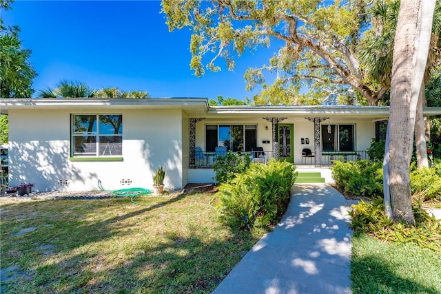 ranch-style house with covered porch, a front lawn, and stucco siding