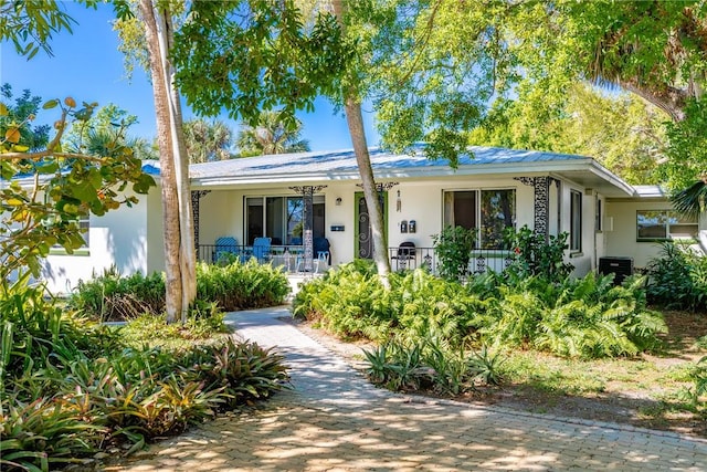 single story home featuring covered porch and stucco siding