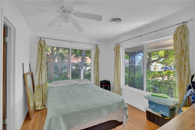 bedroom with visible vents, baseboards, and wood finished floors