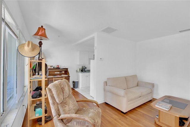 living room featuring light wood-type flooring and visible vents