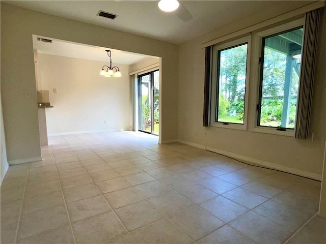 unfurnished room featuring light tile patterned flooring and ceiling fan with notable chandelier