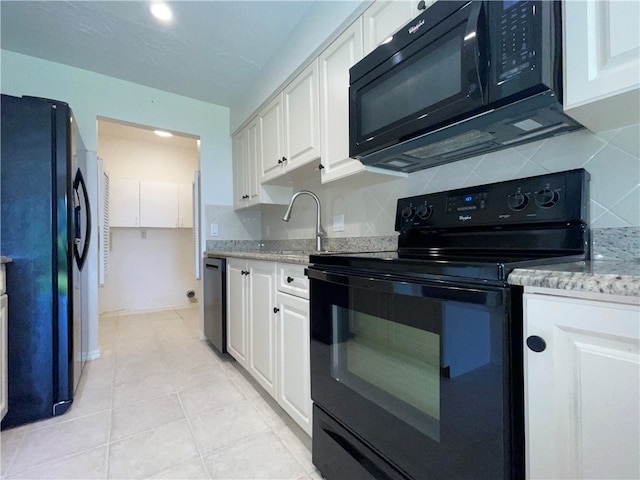 kitchen featuring white cabinets, black appliances, light tile patterned floors, and light stone counters