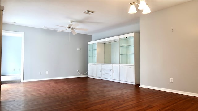 unfurnished bedroom featuring ceiling fan with notable chandelier and dark hardwood / wood-style floors