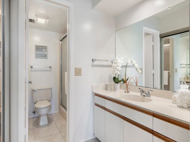 bathroom with tile patterned flooring, vanity, toilet, and a shower with shower door