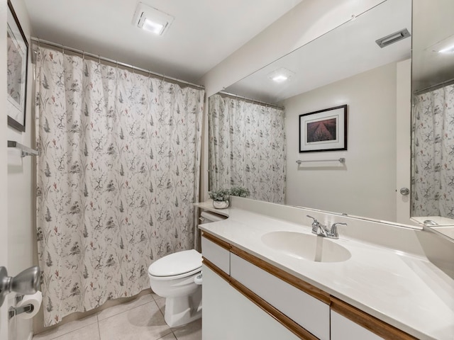 bathroom with toilet, vanity, tile patterned floors, and walk in shower