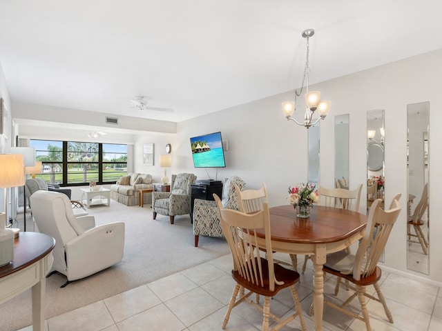 carpeted dining room featuring ceiling fan with notable chandelier