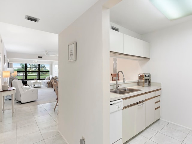 kitchen with white dishwasher, light tile patterned flooring, white cabinetry, and sink