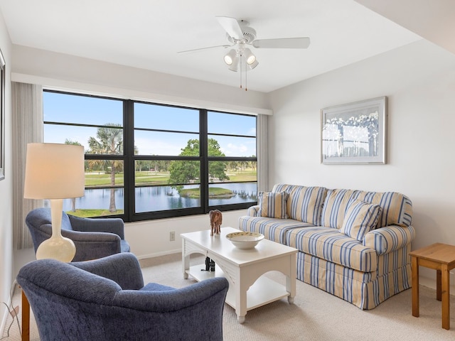 carpeted living room featuring a water view and ceiling fan