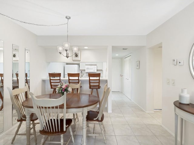 tiled dining area featuring a chandelier