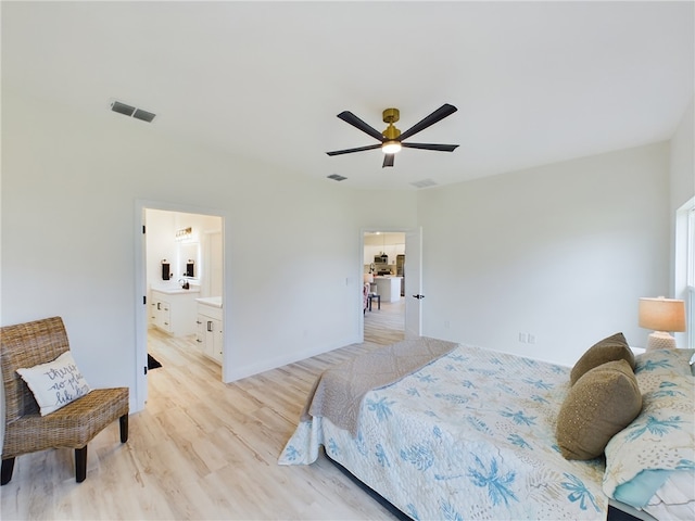 bedroom featuring ceiling fan, light hardwood / wood-style floors, and connected bathroom