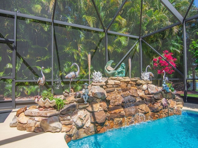 view of pool featuring pool water feature and glass enclosure