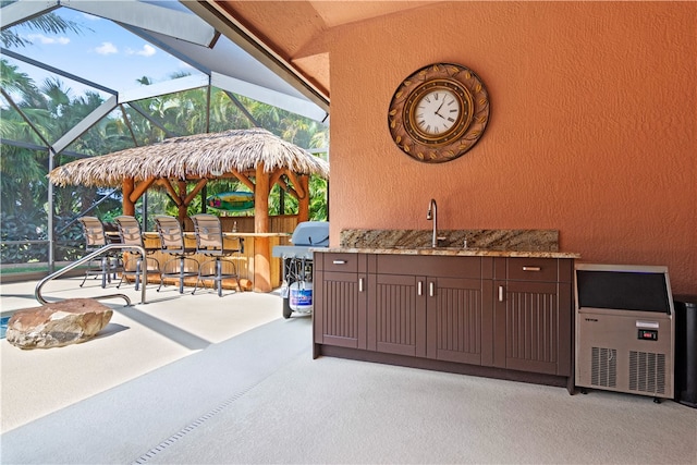 view of patio / terrace with glass enclosure and an outdoor wet bar