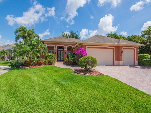 view of front of home featuring french doors, a front yard, and a garage