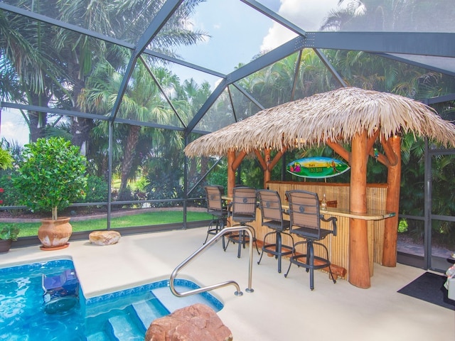 view of patio with glass enclosure and a bar