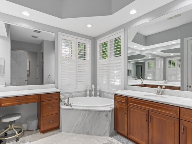 bathroom featuring vanity and a relaxing tiled tub