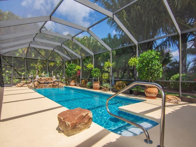 view of pool with a patio and glass enclosure