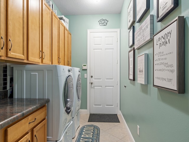 washroom featuring cabinets, independent washer and dryer, a textured ceiling, and light tile patterned floors