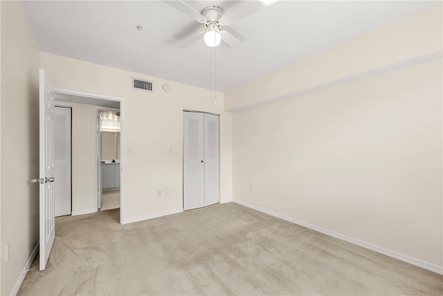 unfurnished bedroom with baseboards, a closet, visible vents, and light colored carpet