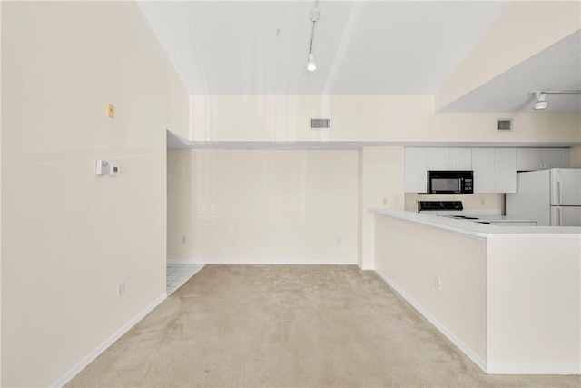 kitchen featuring light carpet, range, freestanding refrigerator, light countertops, and black microwave