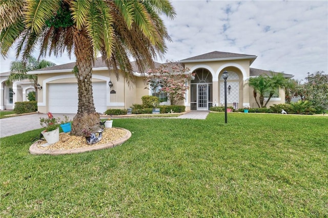 777 Fortunella Cir SW, Vero Beach, FL 32968 - mediterranean / spanish-style home featuring decorative driveway, a front lawn, an attached garage, and stucco siding