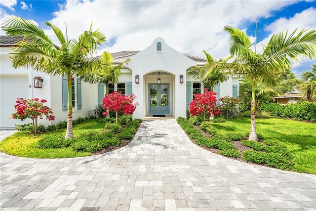 property entrance featuring french doors, a yard, and a garage