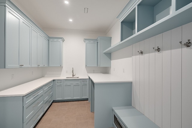 kitchen featuring ornamental molding, gray cabinetry, and sink