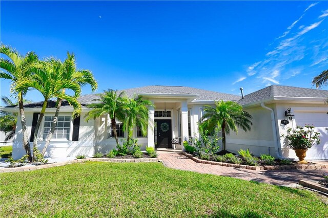 view of front of house featuring a water view, a front yard, and a garage