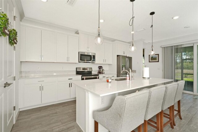 636 Veridian Cir NW, Palm Bay, FL 32907 - kitchen with appliances with stainless steel finishes, light wood finished floors, light countertops, white cabinets, and recessed lighting