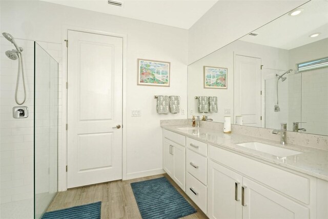 636 Veridian Cir NW, Palm Bay, FL 32907 - full bath featuring double vanity, a tile shower, wood finished floors, and recessed lighting