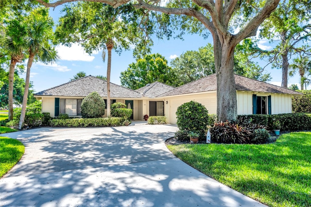 ranch-style home featuring a front lawn and a garage