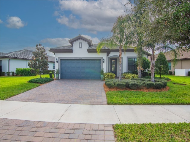 mediterranean / spanish-style home with a garage and a front lawn